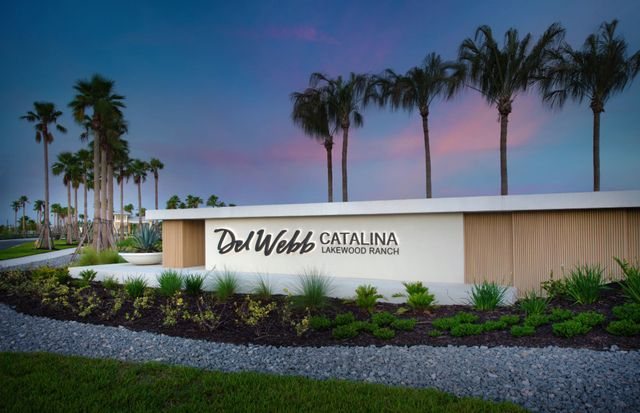 Del Webb Catalina at Lakewood Ranch community entrance monument at dusk, framed by palms