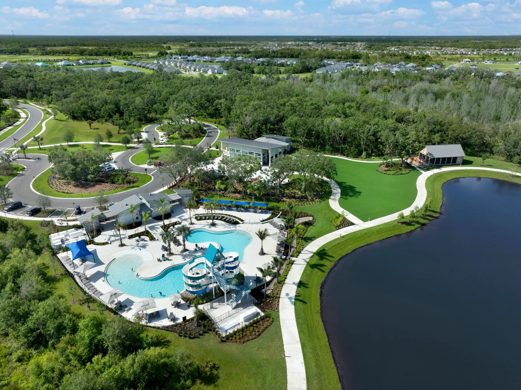 Aerial view of North River Ranch's resort-style community pool with water slide and clubhouse, Parrish FL