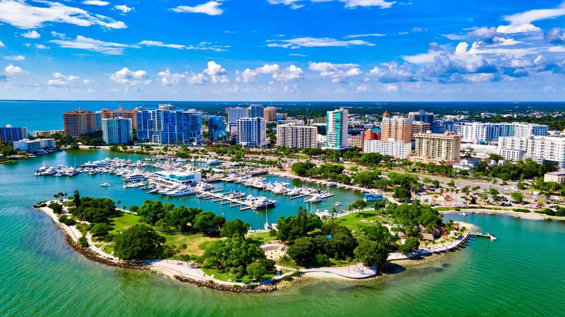 Aerial view of Downtown Sarasota's bayfront marina, waterfront park, and skyline